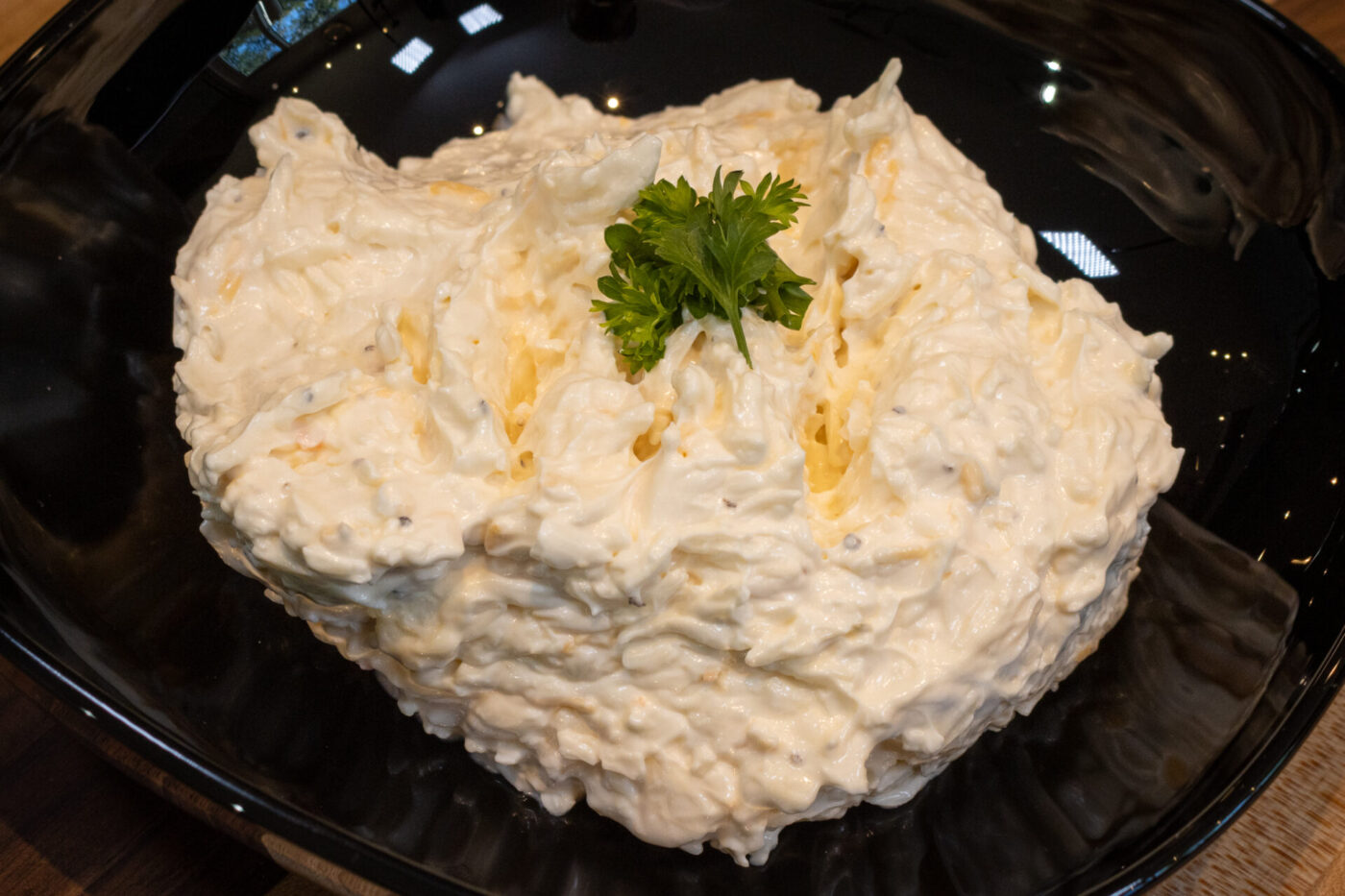 Cheese Garlic Dip Spread Mound of Cheese – Garlic Dip and Spread with parsley garnish on a black plate.
