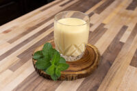 Czech Egg Liqueur – Czech Eggnog Glass of Czech Egg Liqueur – Czech Eggnog with ice, on a wood slice with fresh mint.