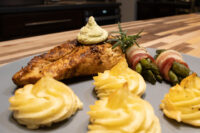 Rosemary Chicken Breasts Seared Rosemary Chicken Breasts topped with herb cream, plated with duchess potatoes and bacon-wrapped asparagus.