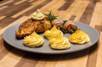 Rosemary Chicken Breasts Seared Rosemary Chicken Breasts topped with herb cream, served with duchess potatoes and bacon-wrapped asparagus.