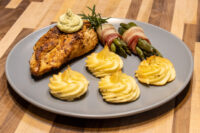Rosemary Chicken Breasts Seared Rosemary Chicken Breasts topped with herb butter and rosemary, served with asparagus and potato swirls.
