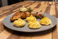 Rosemary Chicken Breasts Rosemary Chicken Breasts topped with herb sauce and rosemary sprig, served with duchess potatoes and bacon-wrapped asparagus.
