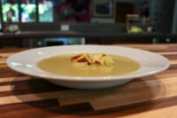 Broccoli Soup Bowl of creamy Broccoli Soup topped with crunchy croutons on a wooden table.