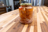 Pickled Sausage Utopenec A glass jar of Pickled Sausage Utopenec with sausage chunks, onions, and chili in vinegar sauce, lid on.