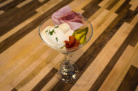 Russian Eggs (Ruské Vejce) Russian Eggs (Ruské Vejce) in a martini glass with ham draped over the rim, pickle, and bacon garnish.