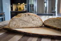 Czech Rye Bread Sliced Czech Rye Bread loaf on a wooden board, showing its dense crumb and dark crust.