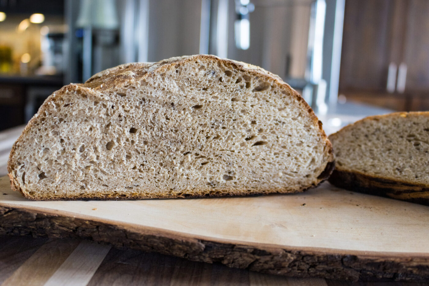 Czech Rye Bread Cross-section of Czech Rye Bread showing a speckled crumb and seeded crust on a wood board.