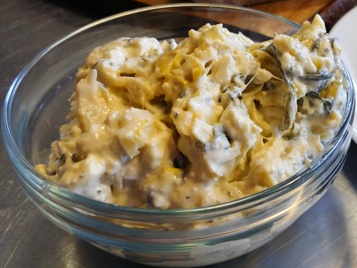 Artichoke Spinach Dip Glass bowl of Artichoke Spinach Dip with creamy texture and visible spinach pieces