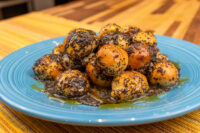 Bobalky with Poppyseeds and Honey piled on a blue plate, dough balls glistening with syrup
