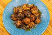 Bobalky with Poppyseeds and Honey piled on a blue plate, dark poppy seeds coating golden dough, honey glaze pooling below.