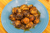 Bobalky with Poppyseeds and Honey piled on a blue ridged plate, glazed and dusted with poppy seeds.