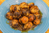 Bobalky with Poppyseeds and Honey piled on a blue ceramic plate, honey glaze pooling at the base.