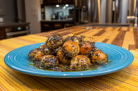 Bobalky with Poppyseeds and Honey: golden dough balls in black poppy seeds on a blue plate with syrup