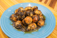 Pile of bobalky with poppyseeds and honey, glazed and glossy, on a blue plate