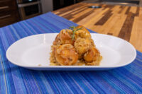 Bobalky with Sauerkraut piled on a white plate, golden buns topped with sauerkraut and a rosemary sprig