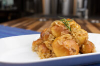 Bobalky with Sauerkraut Bobalky with Sauerkraut piled on a white plate, garnished with a small herb sprig, set on a blue placemat.