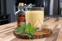 Czech Egg Liqueur – Czech Eggnog Czech Egg Liqueur – Czech Eggnog in a cut-glass tumbler beside a Božkov rum bottle and mint.