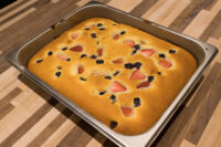 Bublanina (Czech Bubble Cake) Baked Bublanina (Czech Bubble Cake) with strawberries and blueberries in a metal pan.