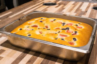 Bublanina (Czech Bubble Cake) Golden Bublanina (Czech Bubble Cake) with strawberries and blueberries baked in a metal pan on a wood table