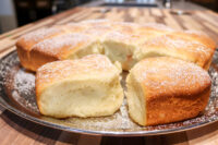 Buchty – Czech Sweet Filled Buns Golden buchty – Czech sweet buns – pulled apart on a metal plate, dusted with powdered sugar.