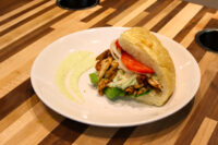 Chicken Gyros Chicken Gyros sandwich with grilled chicken strips, lettuce, tomato and onion in a crusty roll.