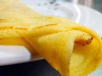 Crepes Folded Crepes with a browned filling visible inside, resting on a white plate.