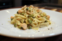 Fettuccine Alfredo with Salmon Plated Fettuccine Alfredo with Salmon topped with peas, grated cheese, and cracked black pepper.