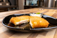 Fried Cheese with Ham Fried Cheese with Ham cut in half showing melted cheese and ham, plated with a creamy dip.