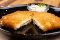 Fried Cheese with Ham Fried Cheese with Ham cut in half showing melted cheese and ham, served with a creamy dip.