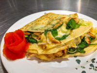 Galettes with Chicken, Spinach, and Brie Cheese Galettes with Chicken, Spinach, and Brie Cheese folded into a wedge on a white plate with a tomato rose garnish.