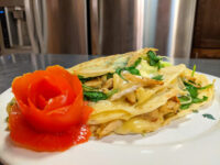 Galettes with Chicken, Spinach, and Brie Cheese Galettes with Chicken, Spinach, and Brie Cheese, folded and sliced open on a plate with a tomato rose garnish