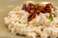 Halušky with Bryndza Cheese Substitution Close-up of Halušky with Bryndza Cheese Substitution topped with crisped bacon and herbs