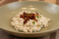 Halušky with Bryndza Cheese Substitution Bowl of Halušky with Bryndza Cheese Substitution topped with crispy bacon and herbs.