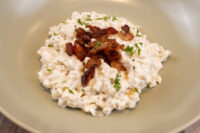 Halušky with Bryndza Cheese Substitution Bowl of Halušky with Bryndza Cheese Substitution topped with crispy bacon and fresh herbs.