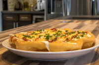 Langos Fried Langos flatbread on a white plate topped with sour cream, cheese, red sauce, and chives
