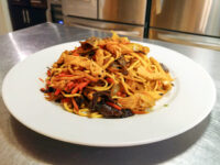 Lo Mein with Chicken Plate of Lo Mein with Chicken showing noodles, chicken, mushrooms, carrot and pepper strips.