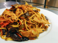Lo Mein with Chicken Plate of Lo Mein with Chicken piled with noodles, chicken, carrots, onions and dark wood ear mushrooms.