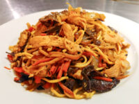 Lo Mein with Chicken A heaping plate of Lo Mein with Chicken, noodles tossed with shredded chicken, carrots, onions, and mushrooms.