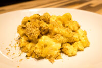 Mac & Cheese Close-up of Mac & Cheese with creamy sauce and golden herb breadcrumb topping on a white plate.