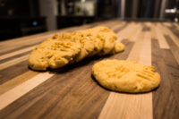 Peanut Butter Cookies Peanut Butter Cookies with crosshatch fork marks piled on a striped wooden countertop