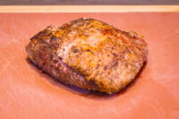 Beef Picanha in Salt Crust Whole roasted Beef Picanha in Salt Crust with a browned, seasoned crust resting on a scratched cutting board.