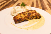 Salmon in Mustard Sauce Seared Salmon in Mustard Sauce fillet on mashed potatoes with pale cream sauce, on a white plate.
