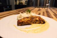 Salmon in Mustard Sauce Salmon in Mustard Sauce fillet on a white plate, seared dark and glossy, resting in a pale creamy sauce beside a swirl of mashed potatoes.