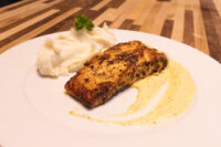 Salmon in Mustard Sauce Seared Salmon in Mustard Sauce fillet with mashed potatoes, parsley, and a pale mustard cream sauce on a white plate.
