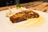 Salmon in Mustard Sauce Seared Salmon in Mustard Sauce fillet with mashed potato and parsley on a white plate
