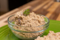 Sardines Dip or Spread Glass bowl of Sardines Dip or Spread garnished with parsley, on a green plate with bread