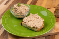 Sardines Dip or Spread Sardines Dip or Spread on toasted bread beside a glass bowl of the same mixture on a green plate