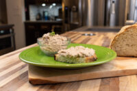 Sardines Dip or Spread Sardines Dip or Spread on a slice of toasted bread beside a glass bowl of the same spread on a green plate