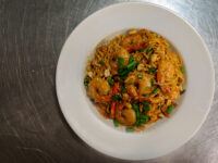 Thai Noodles with Shrimp Overhead shot of Thai Noodles with Shrimp topped with scallions, peanuts, and sesame seeds in a white bowl.
