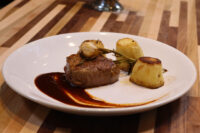 Filet Mignon with Demi-Glace Sauce Filet Mignon with Demi-Glace Sauce plated with rosemary, roasted potatoes, and a dark sauce swirl.